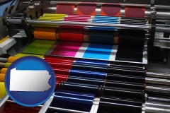 pennsylvania map icon and an offset printing press with CMYK ink rollers
